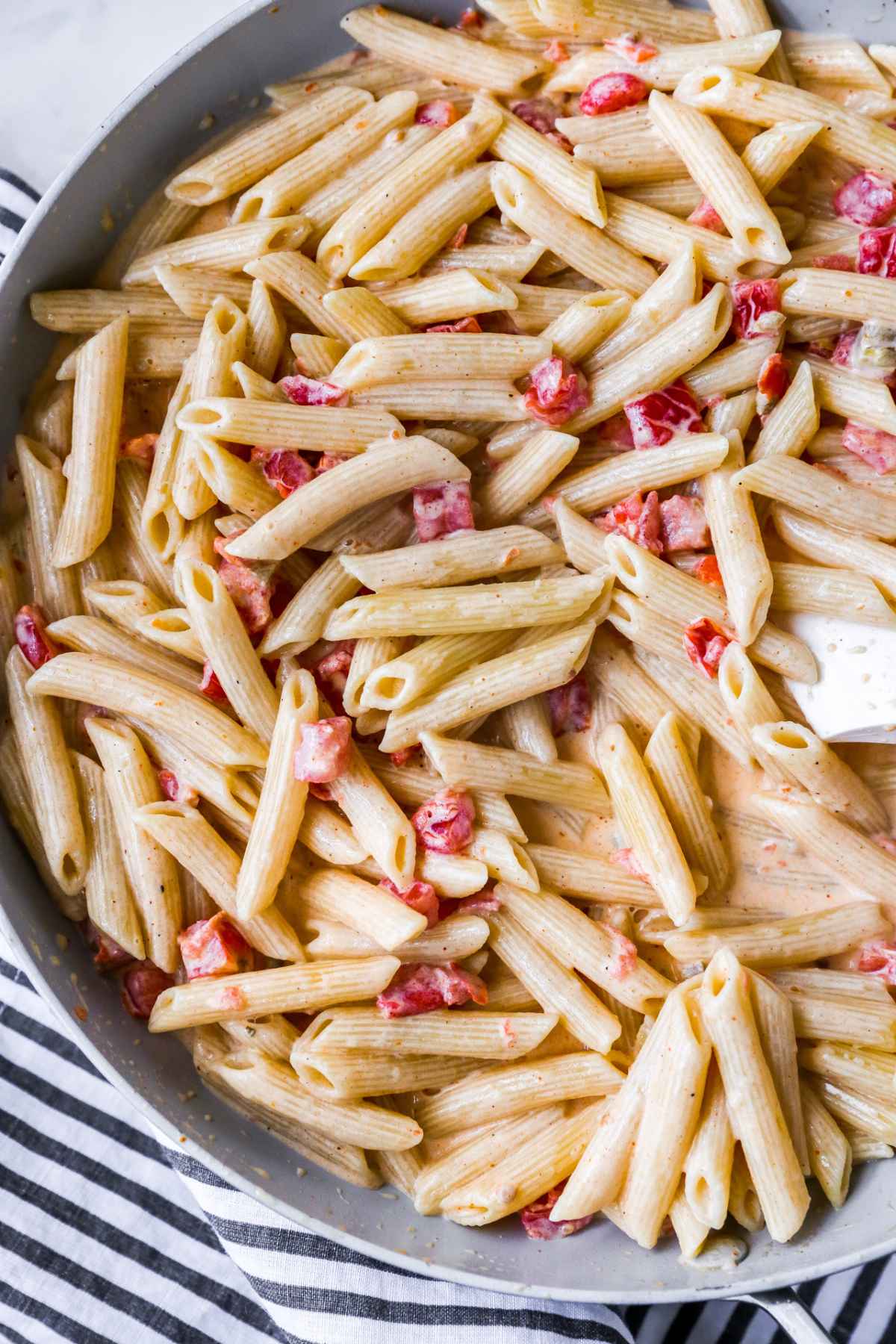 Stirring pasta with creamy sauce.