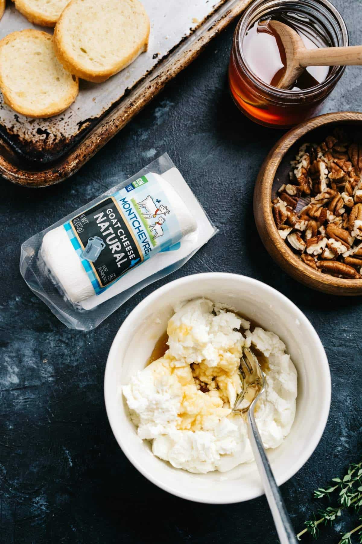 Mixing goat cheese with honey in a small white bowl.