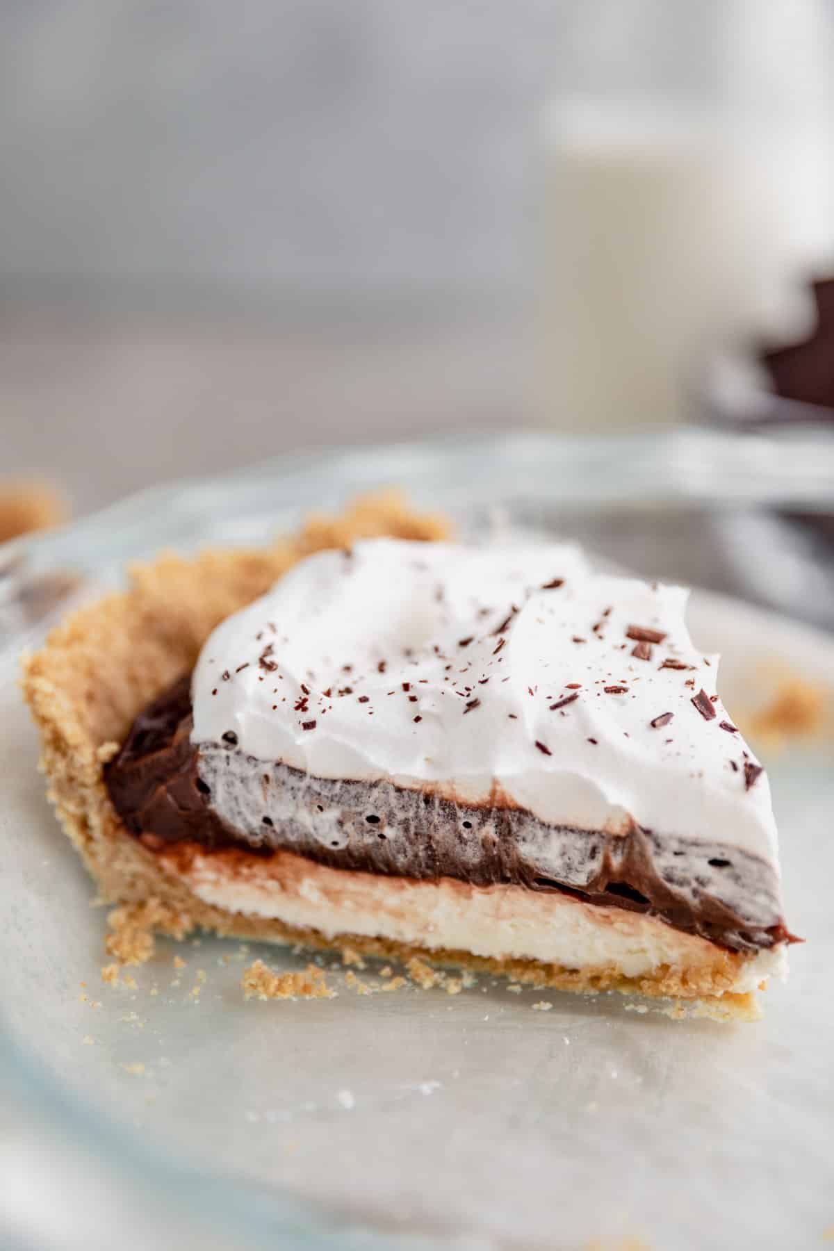 Slice of layered chocolate pudding pie in a pie dish.