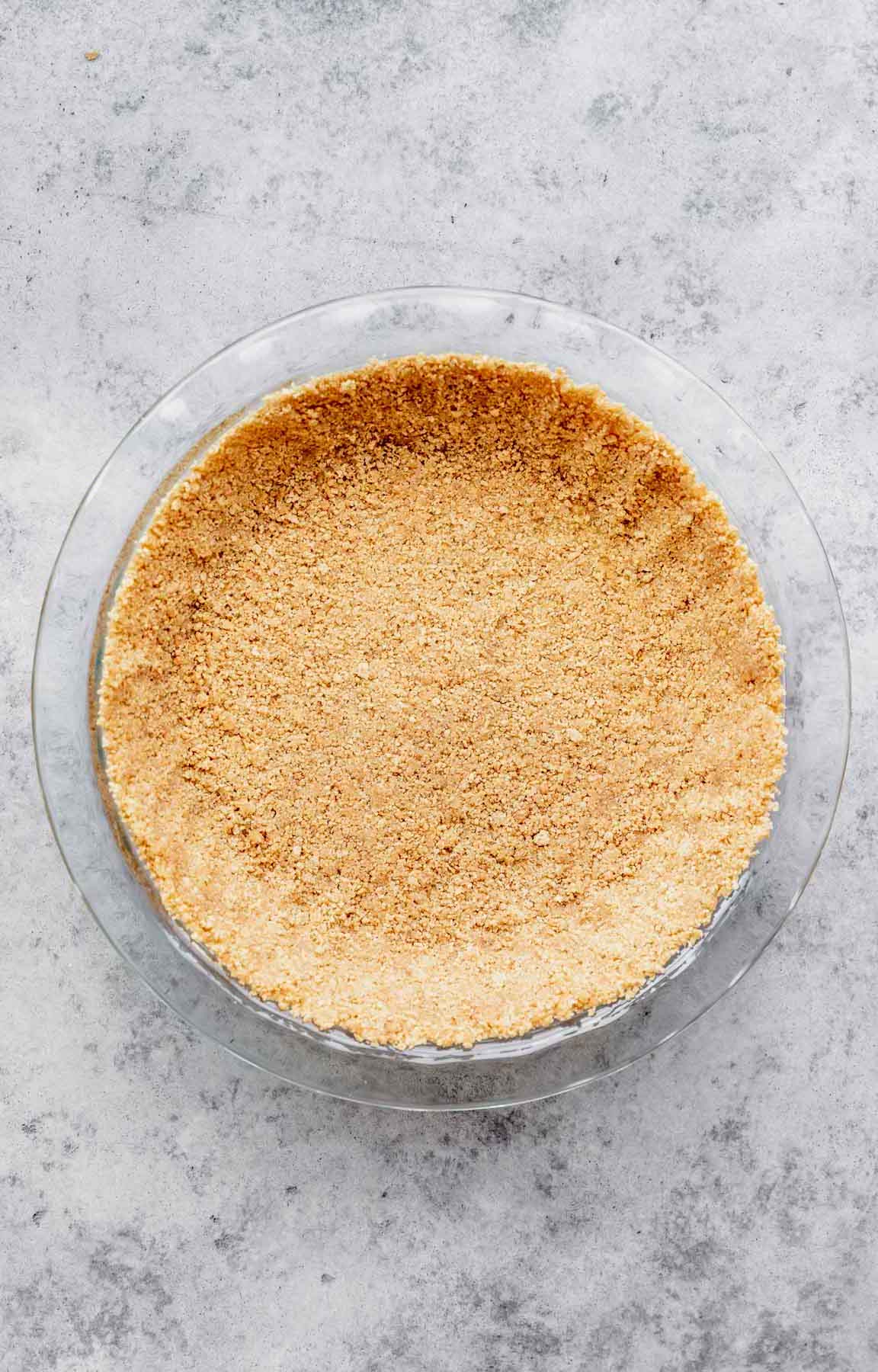 Graham cracker crumb mixture pressed into a pie dish.