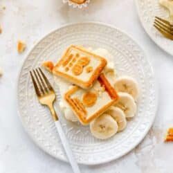 Banana pudding on a white plate with Chessman cookies on top.