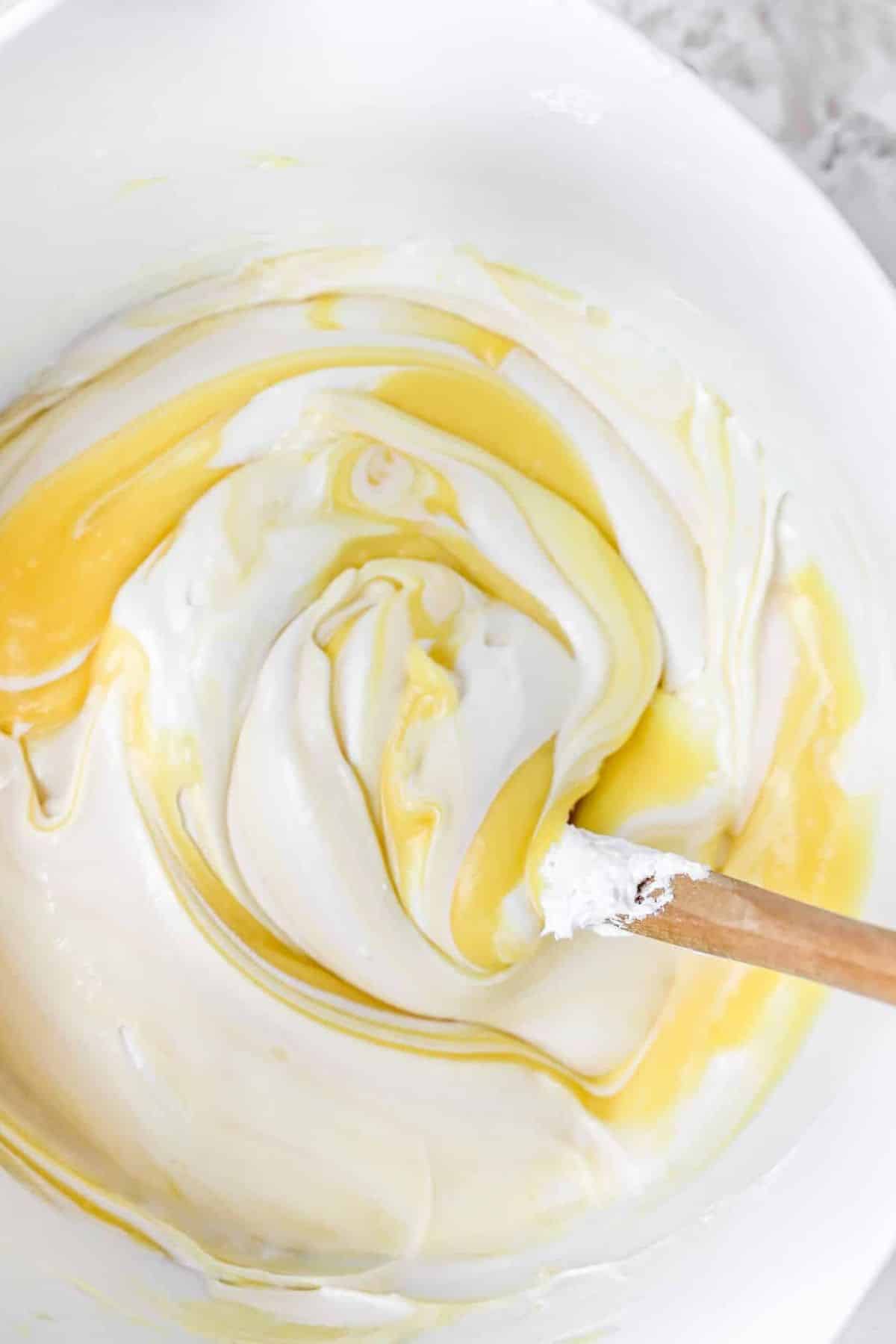 Stirring Cool Whip into pudding mixture in a large bowl.