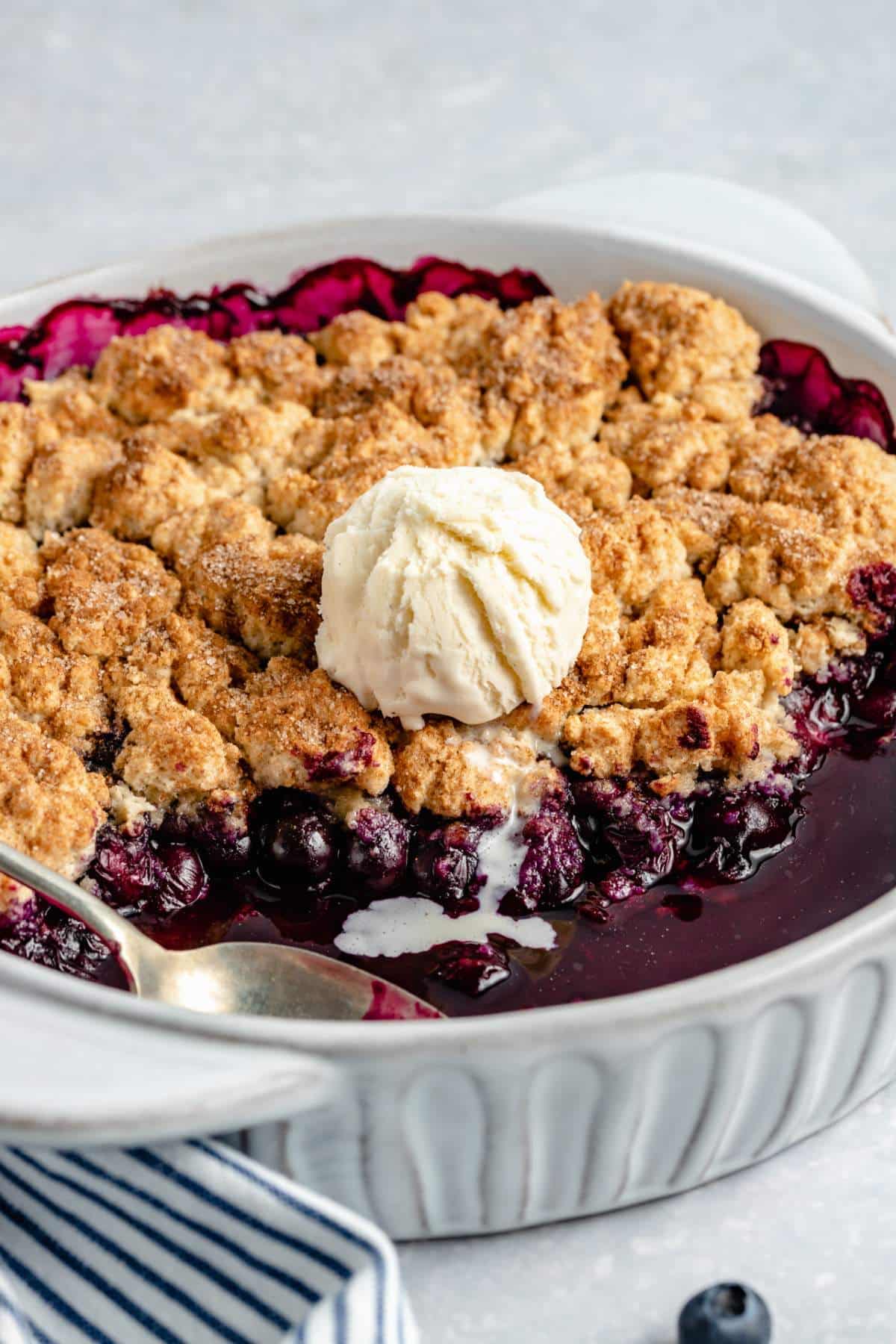 Blueberry cobbler topped with a scoop of ice cream.