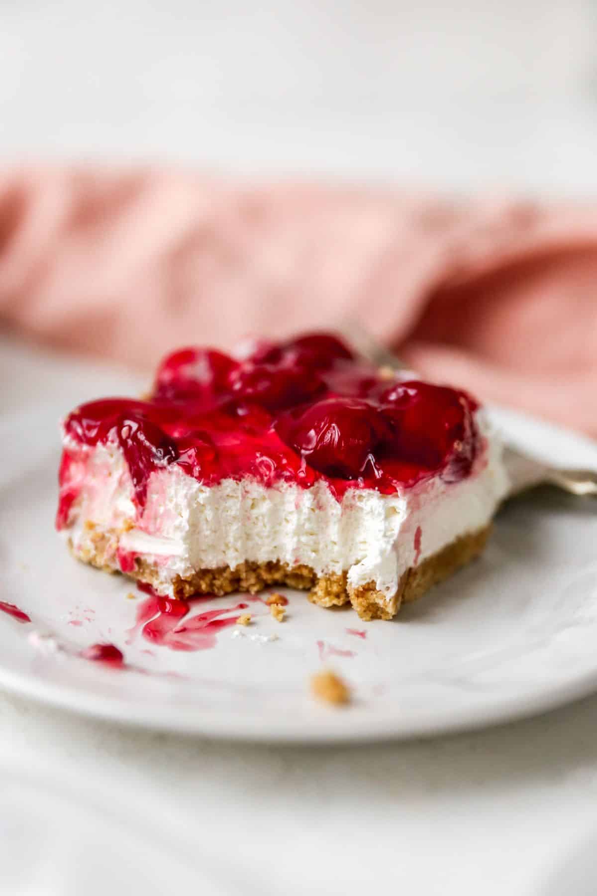 A slice of cherry dessert that has been bitten into.