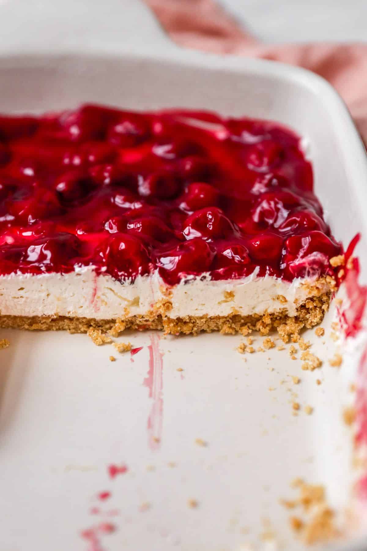 Cherry delight in a pan with slices taken out.