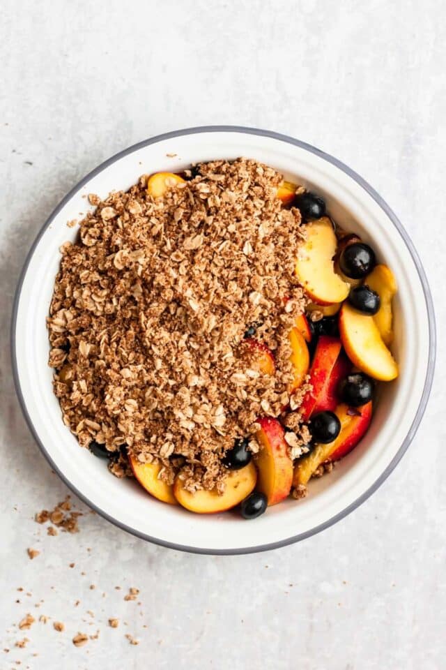 Peach blueberry crisp with part of the oat topping added.