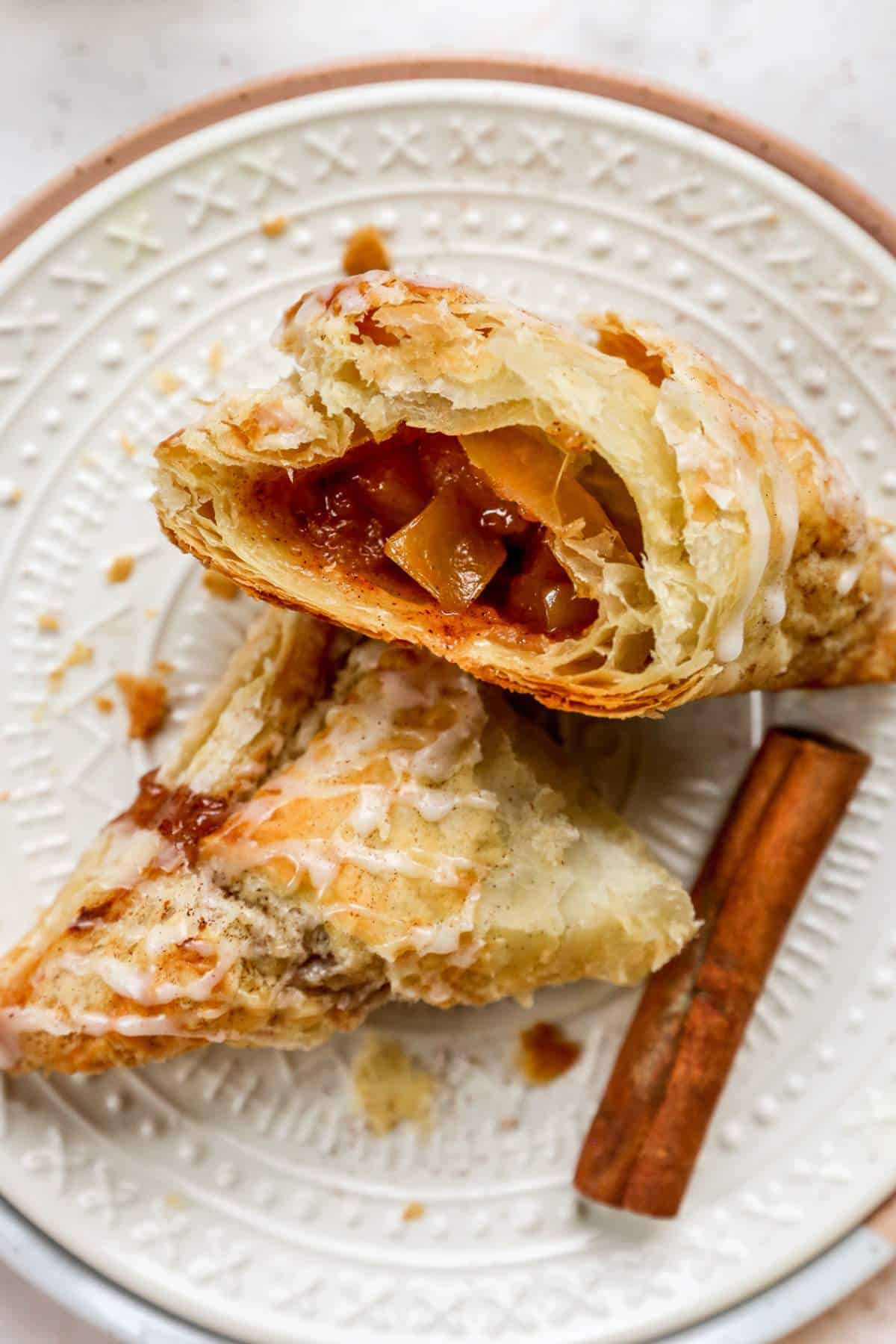 Apple turnovers served on a plate with a bite taken out of one.