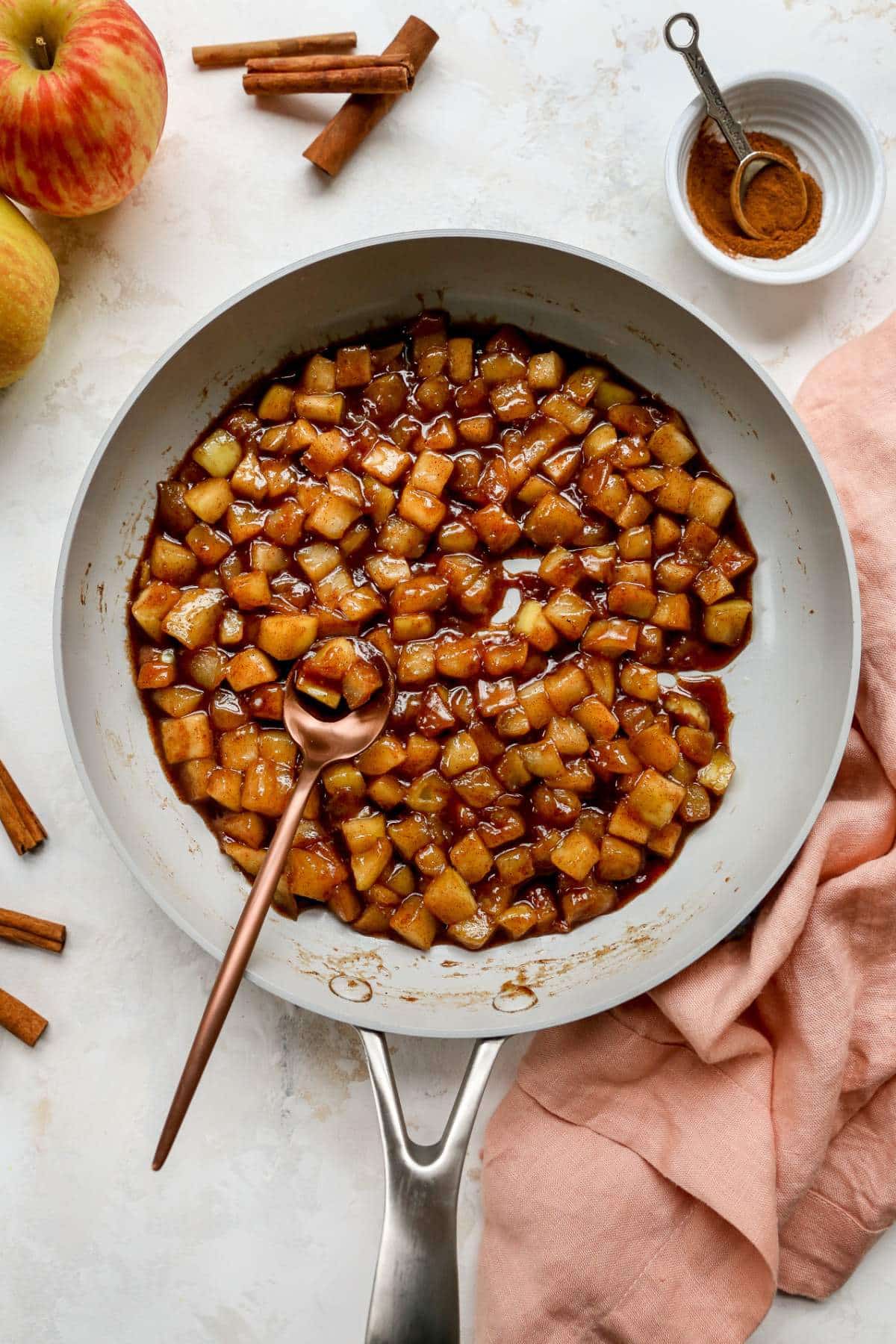 Cooking diced apple in a large pan.