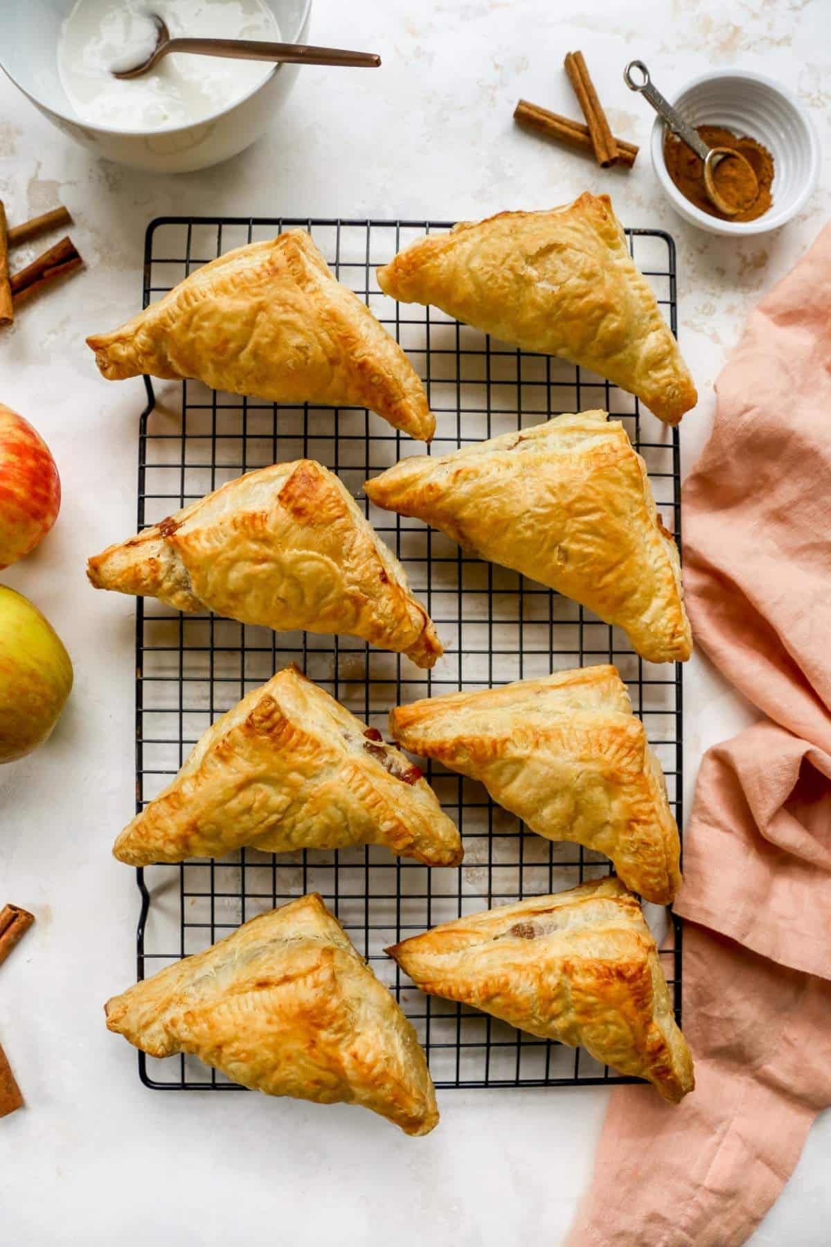 Baked apple turnovers on a wire rack.