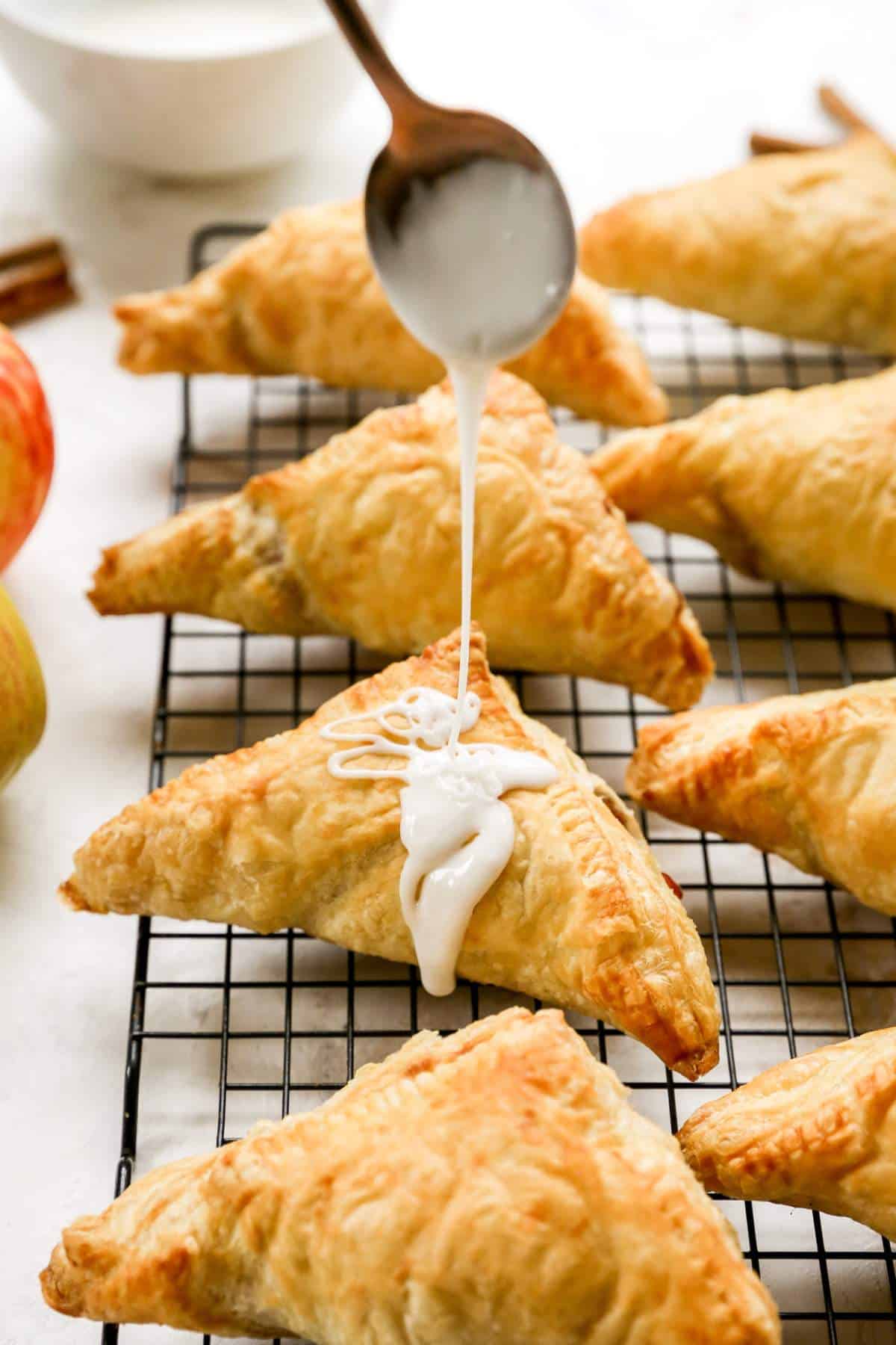 Drizzling apple turnovers with icing.