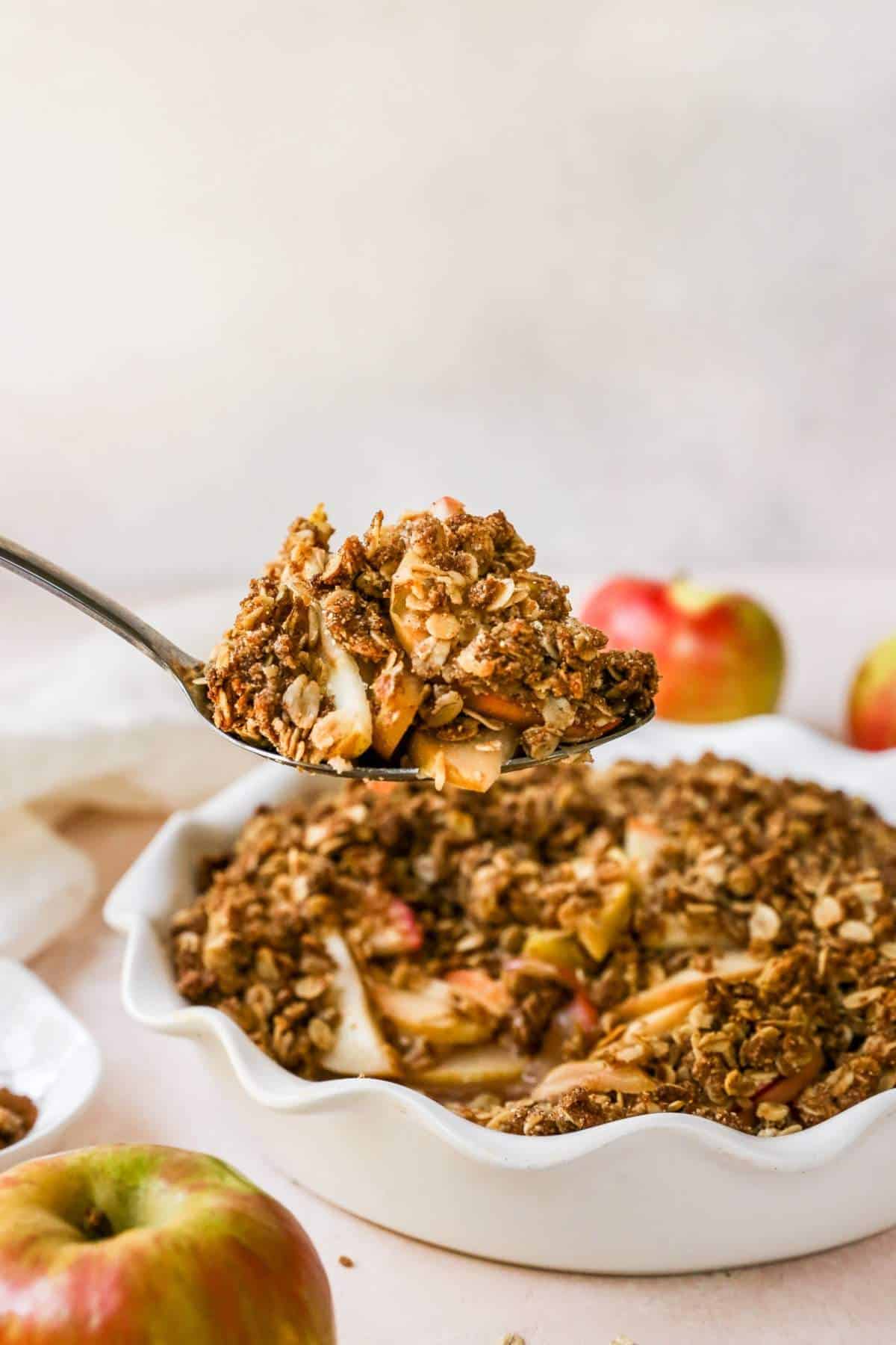 Serving healthy apple crisp using a serving spoon.