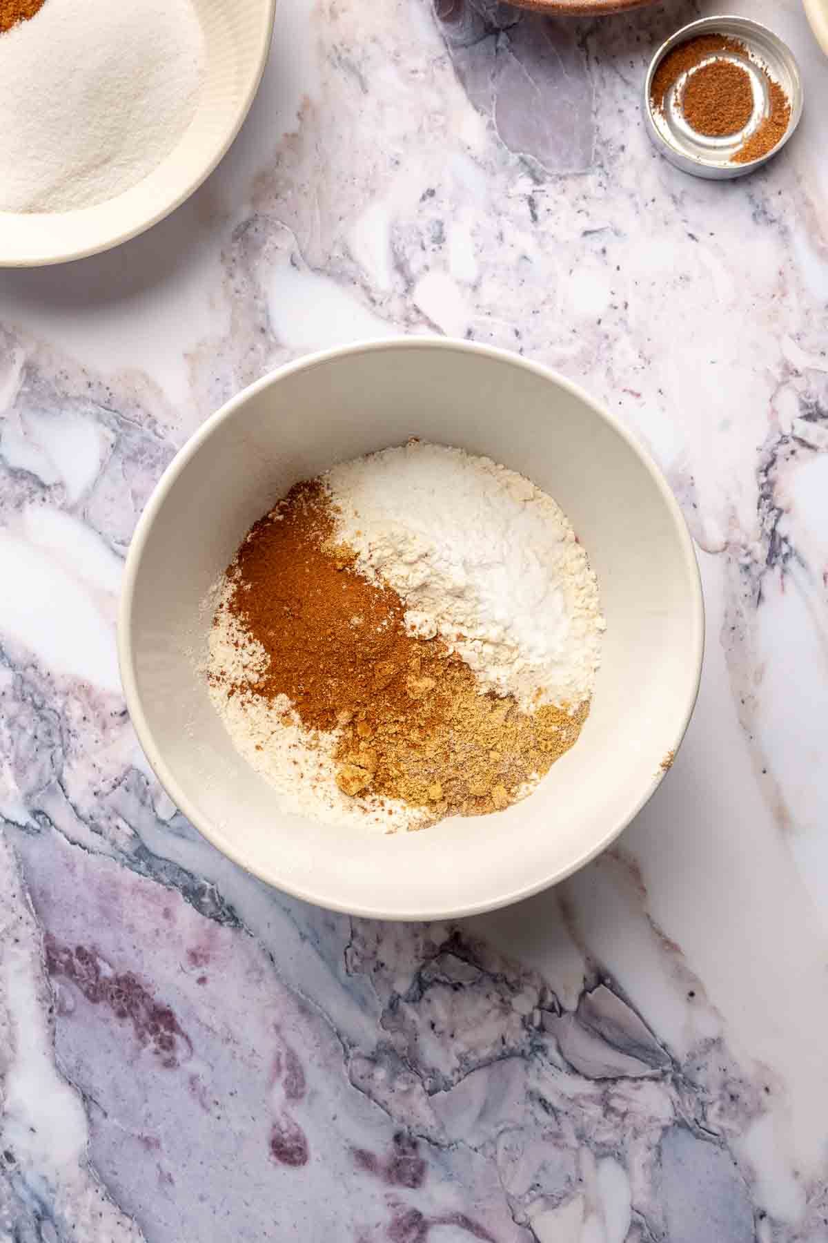 Whisking flour with spices in a large bowl.