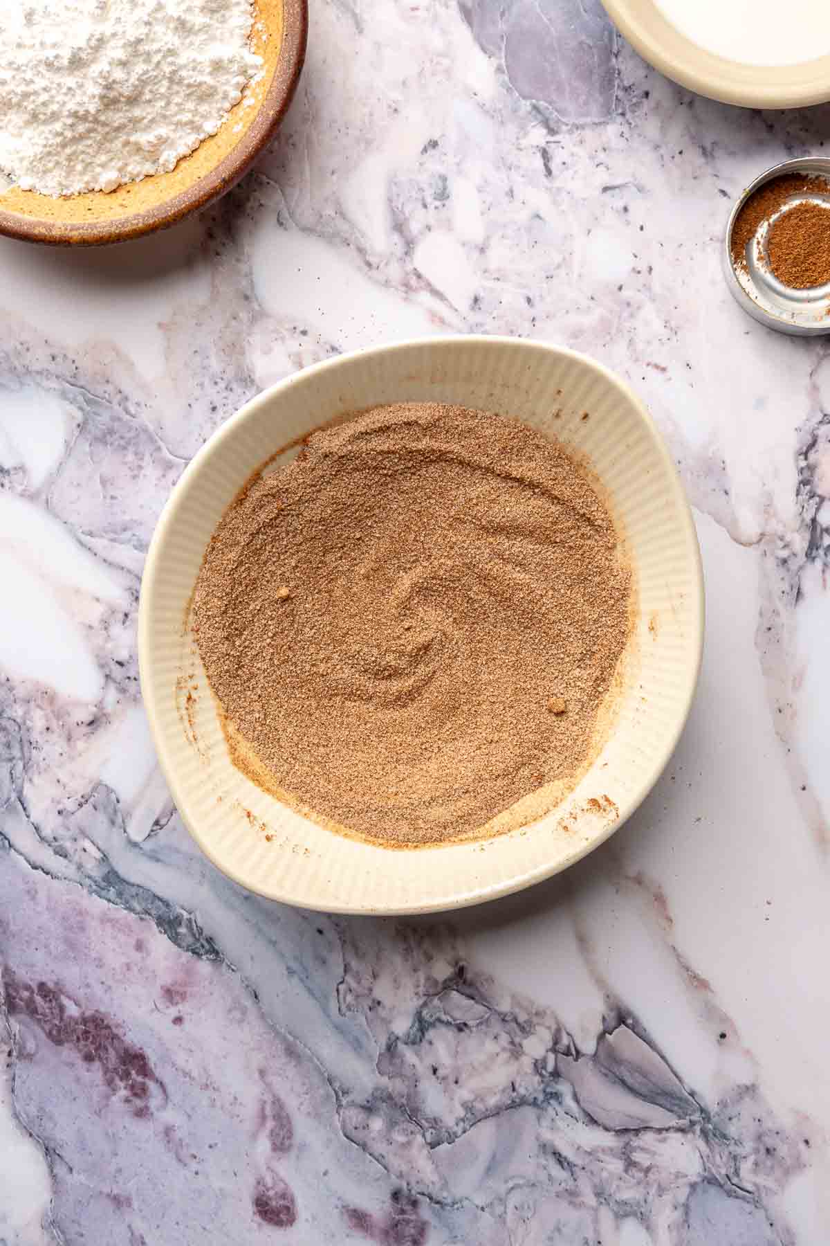 Cinnamon and sugar mixture in a small white bowl.