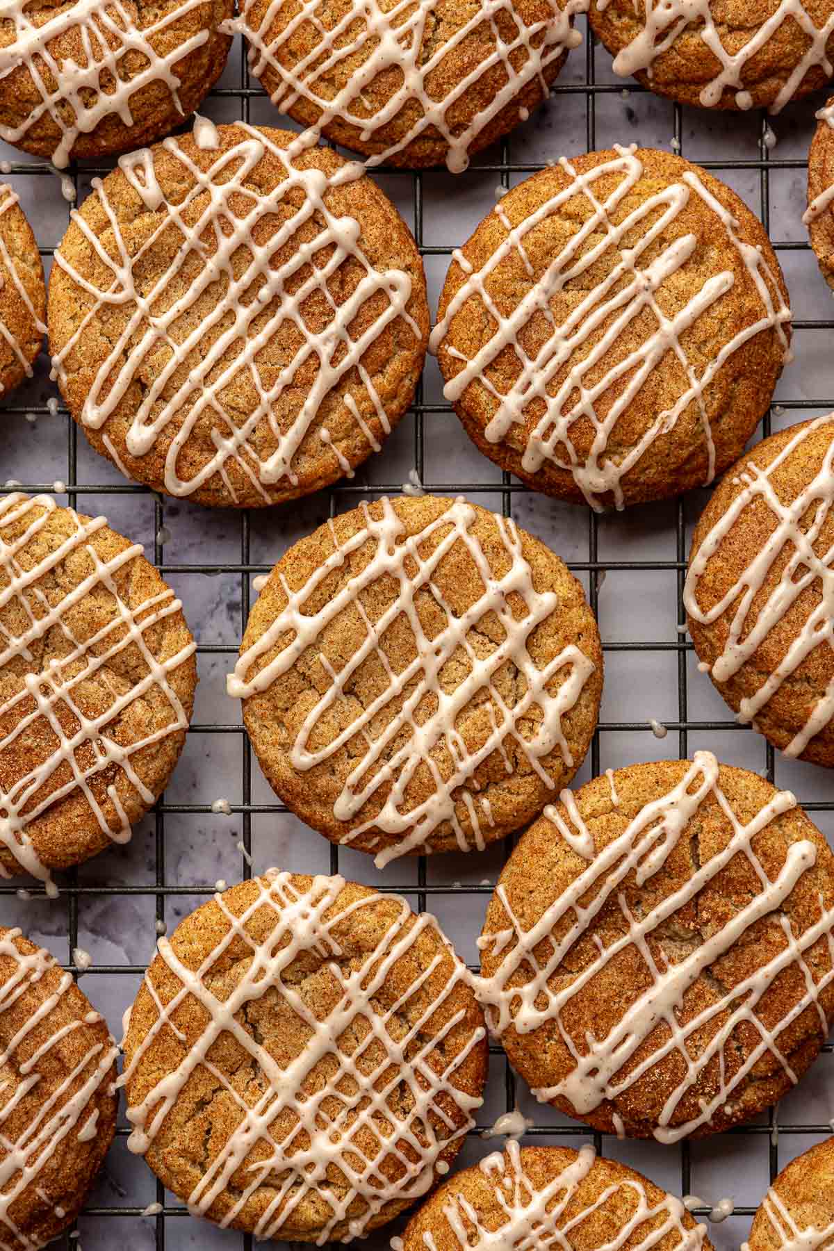 Icing drizzled over cookies on a wire rack.