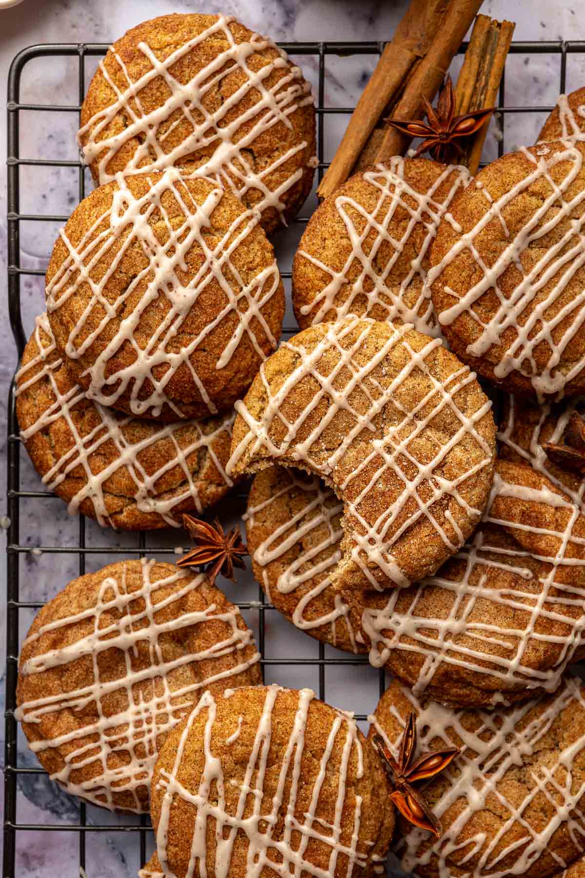 A bite out of one cookie stacked with others on a wire rack.