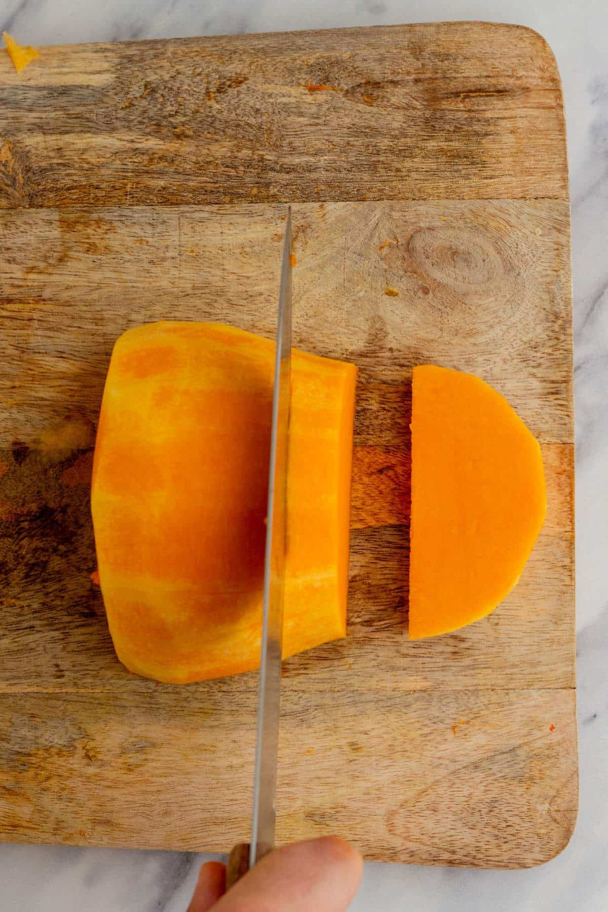 Cutting slices of a butternut squash.