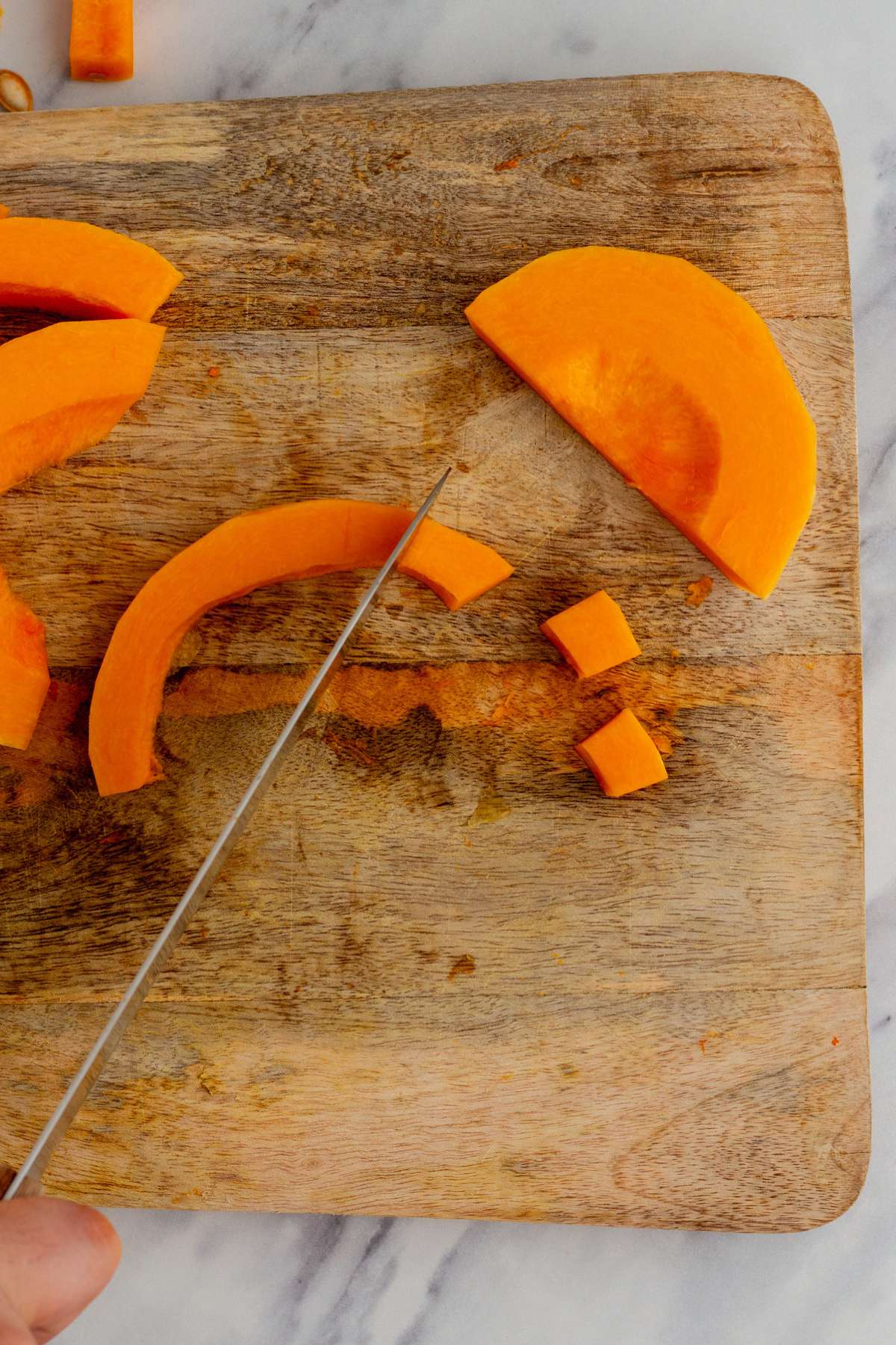 Dicing slices of a butternut squash.