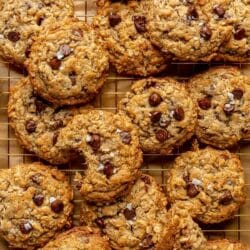 Cowboy cookies stacked on a wire rack.