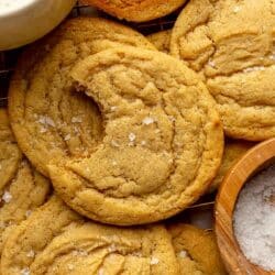 Chocolate chipless cookies near a glass of milk, one with a bite taken out.