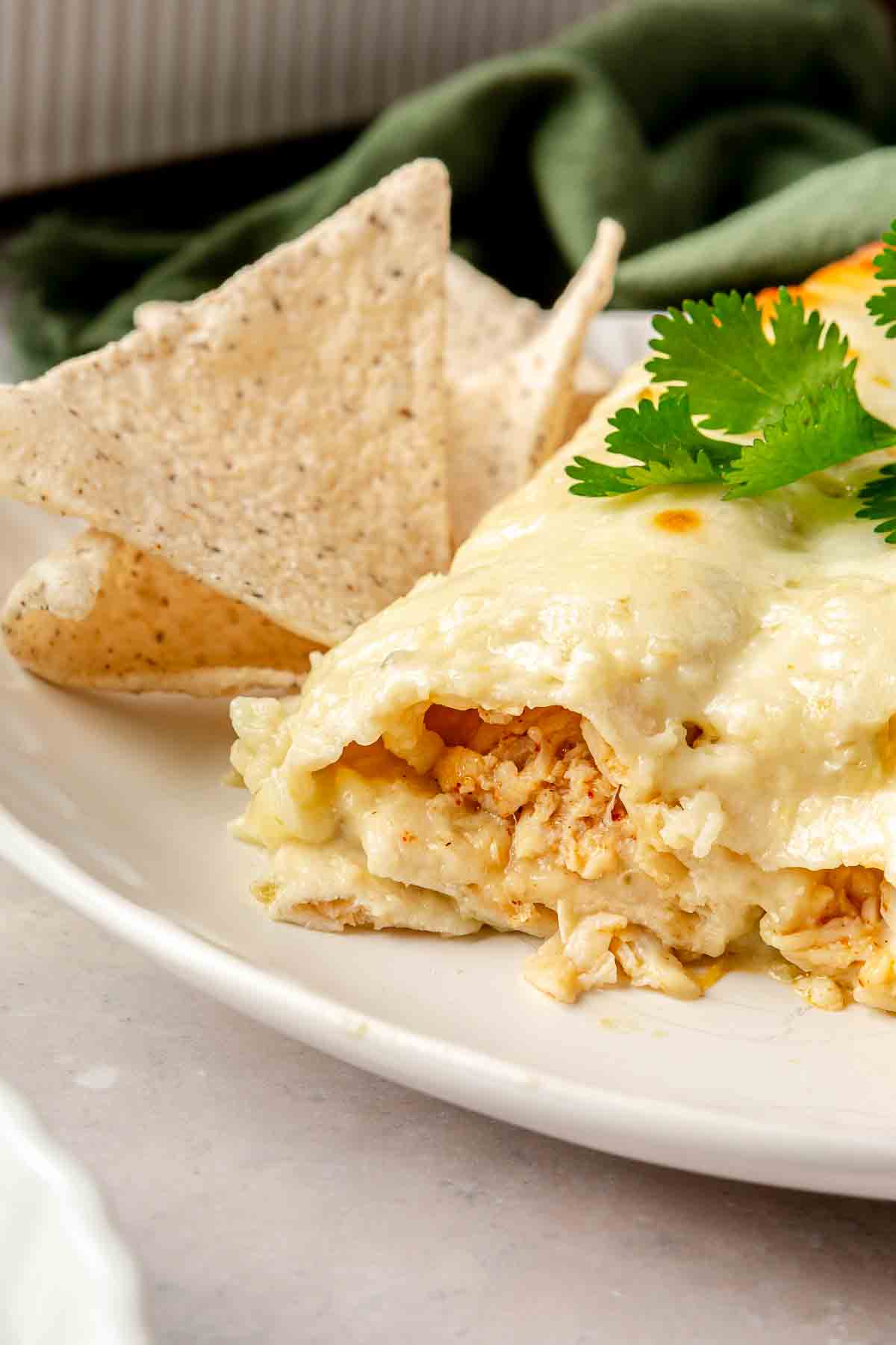 Chicken enchiladas on a plate with chips.