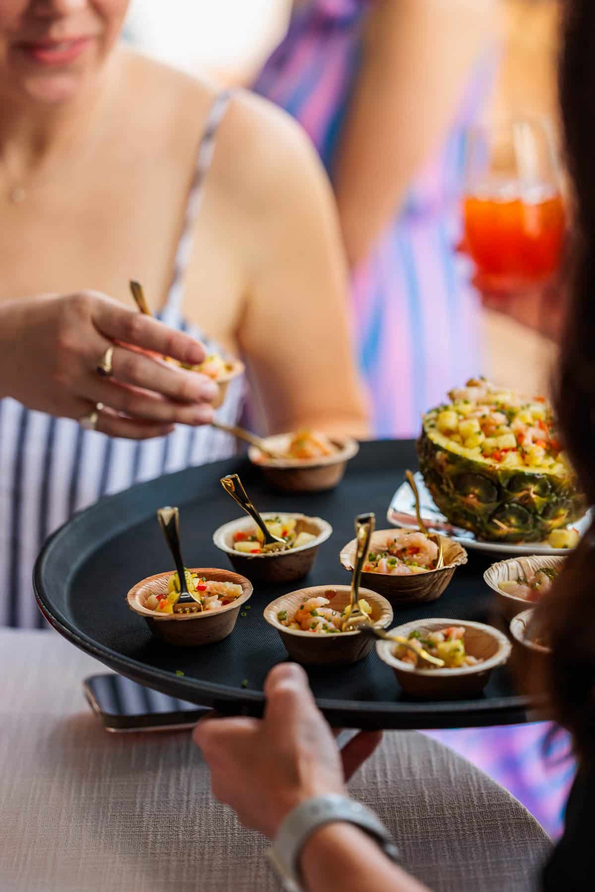 Shrimp ceviche served in small cups on a tray.