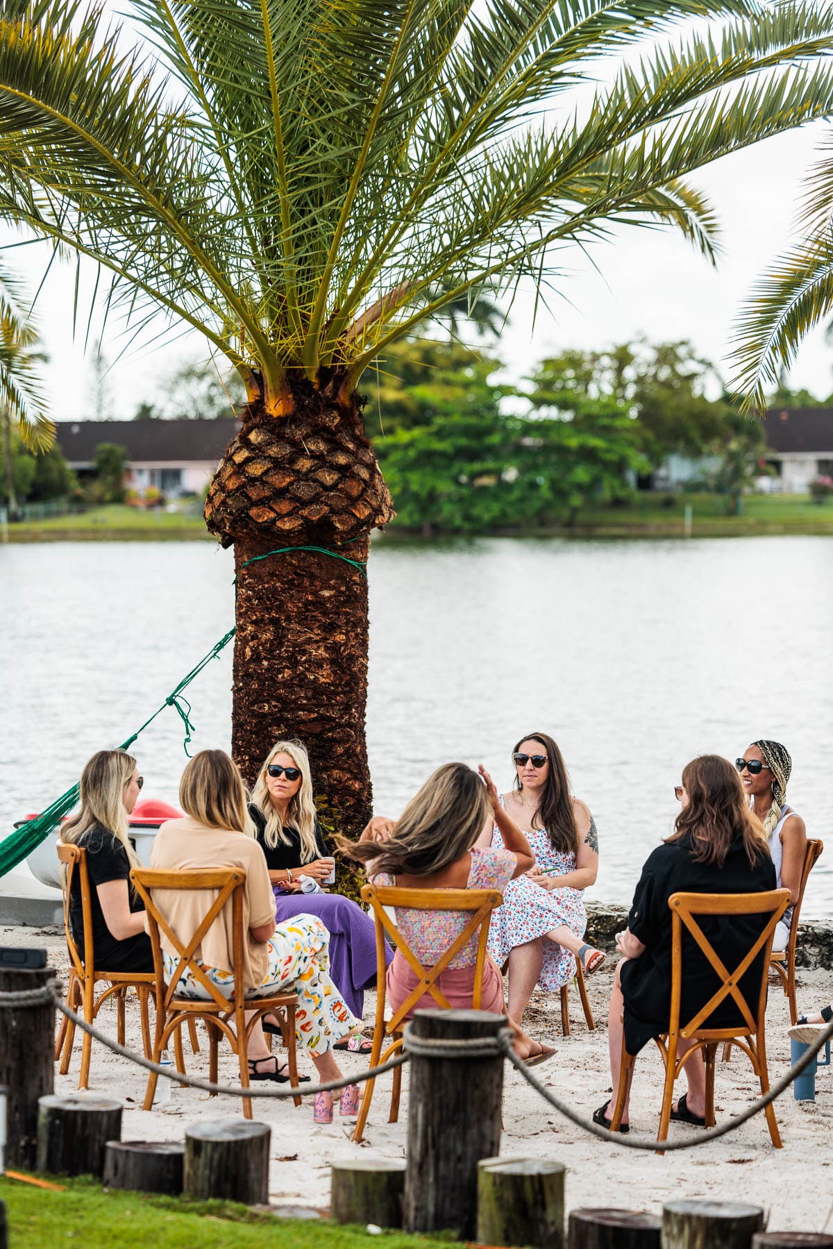 Group of women sitting in chairs near a lake.