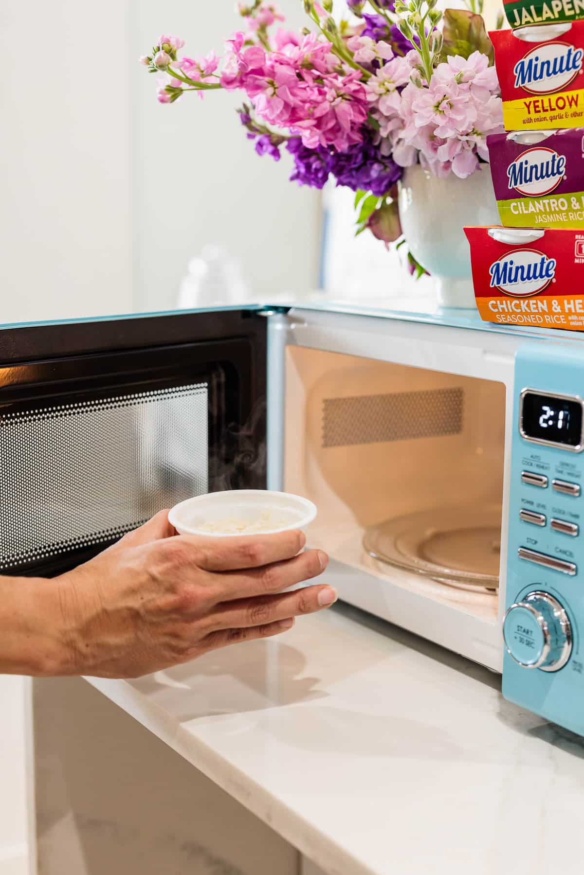 Placing a rice cup into a microwave.