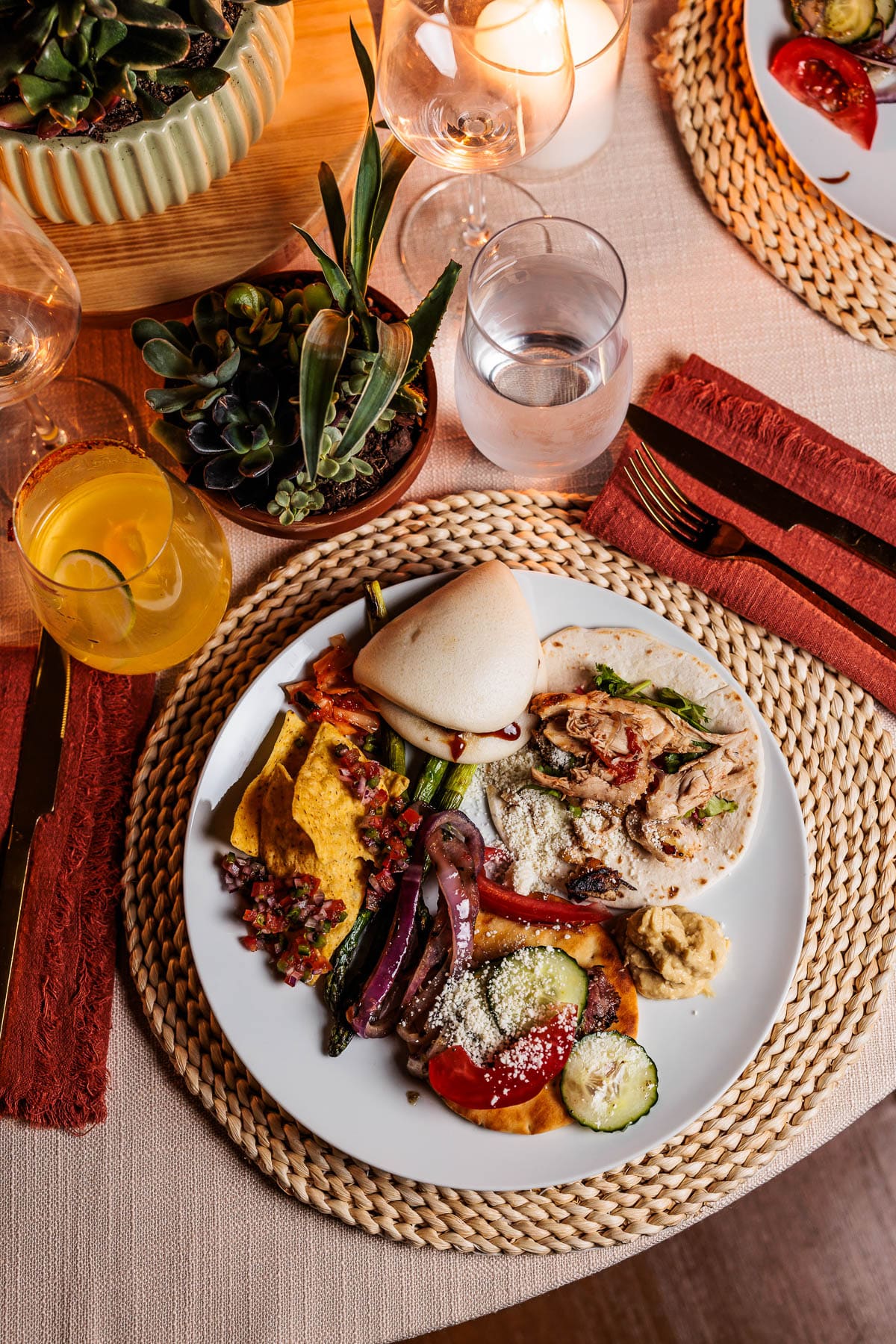 Different grilled foods including a taco on a white plate setting on a table.