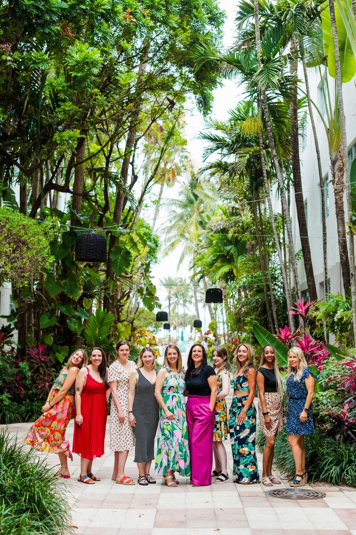 Group of women standing in an outside area under trees.