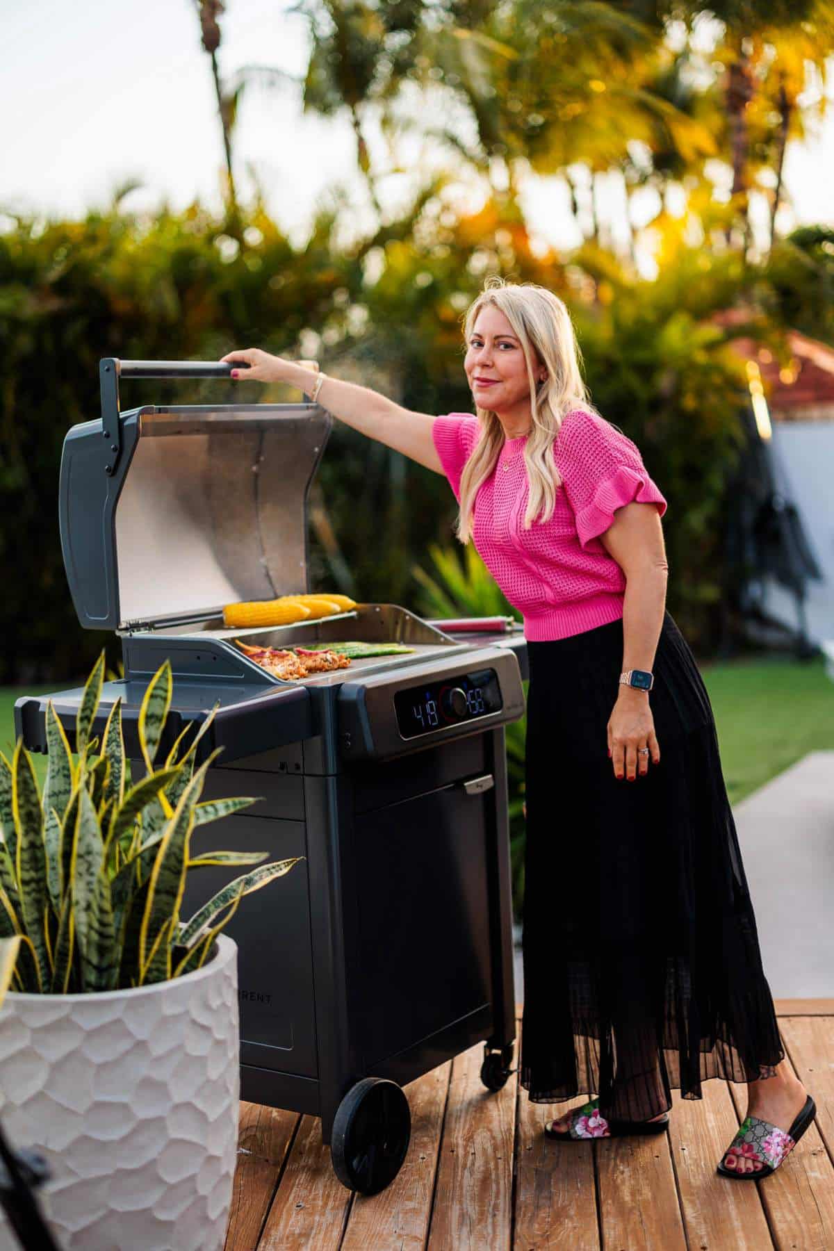 Woman opening lid to grill.