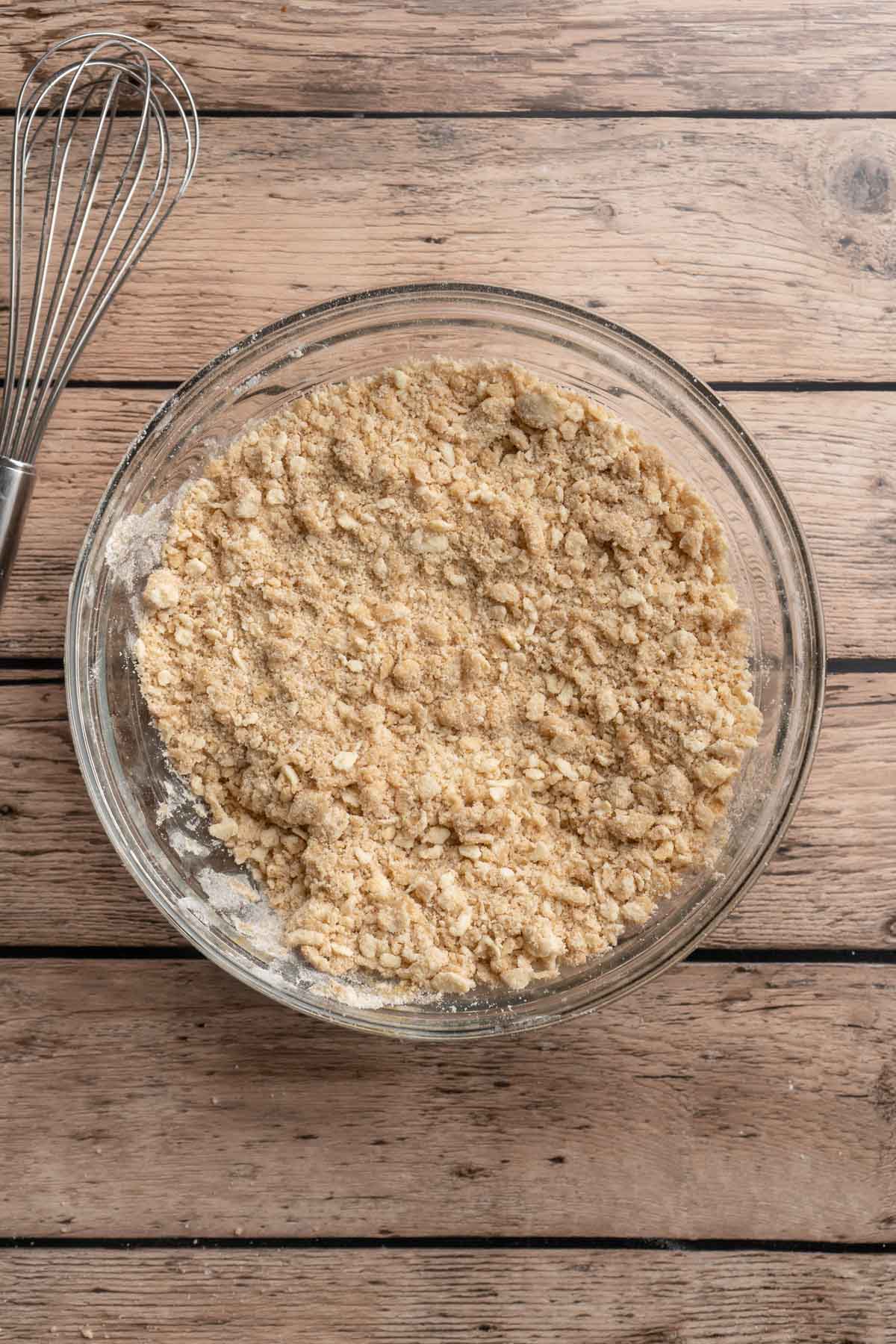 Crumble mixture in a large glass mixing bowl.