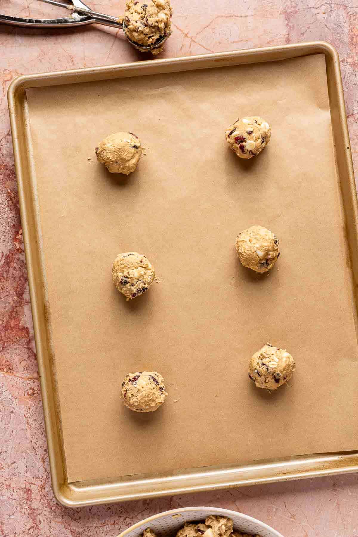 Dough balls on parchment lined cookie sheet.