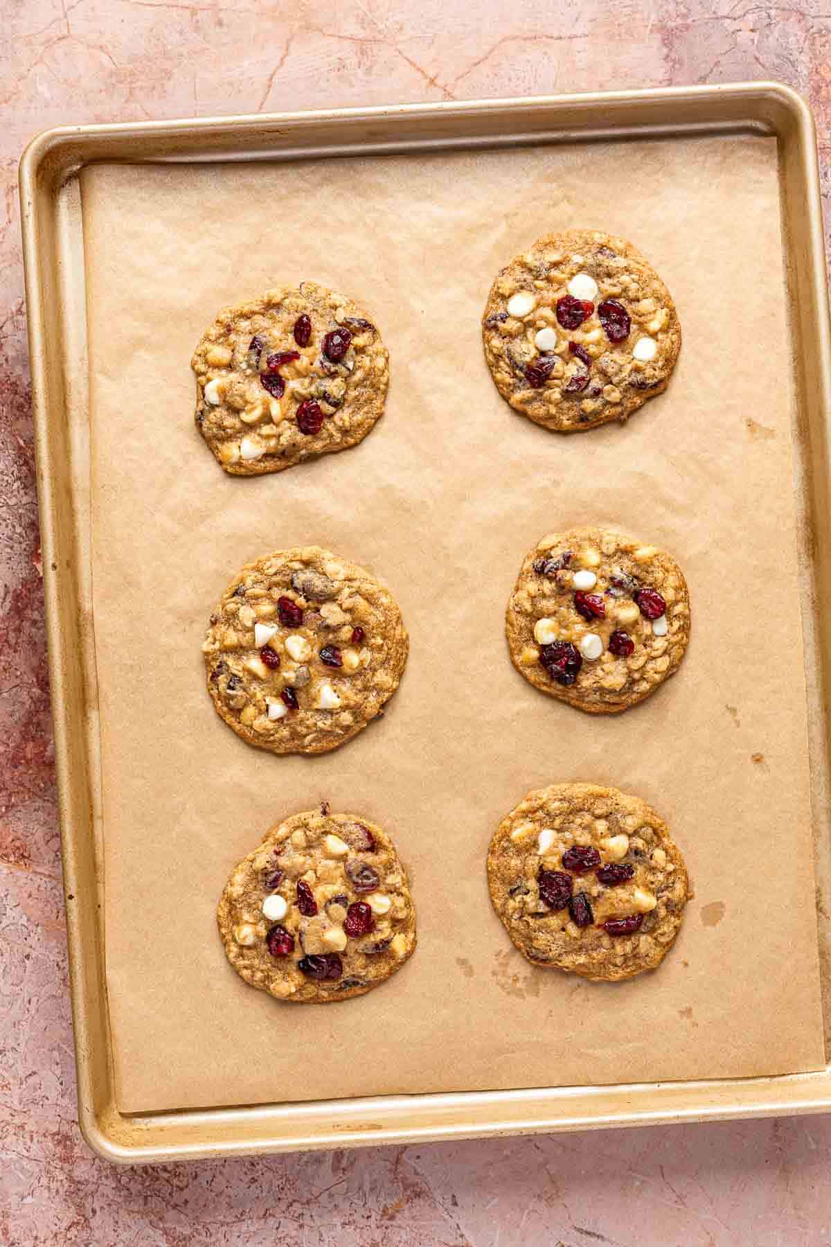 Baked cranberry oatmeal cookies on a baking sheet.