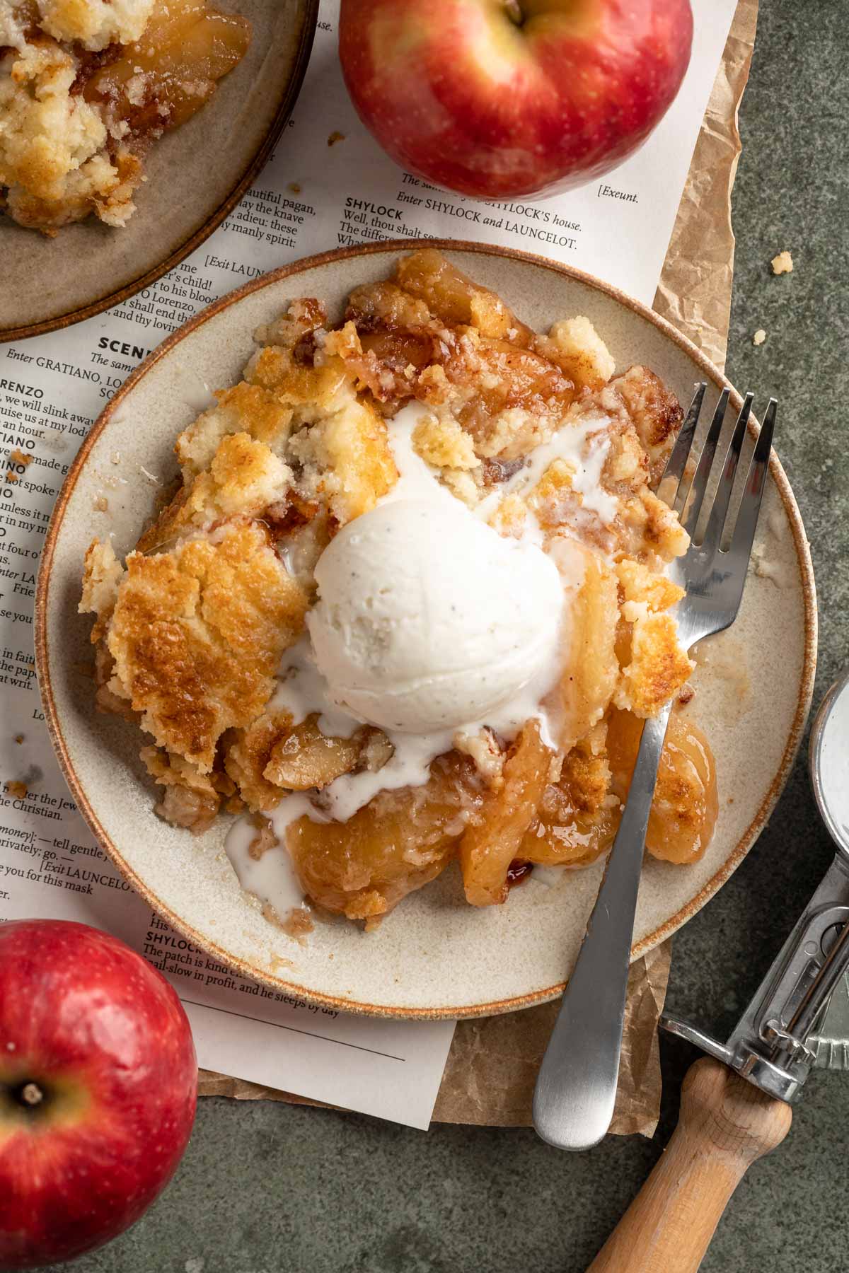 Serving of apple dump cake topped with a scoop of ice cream on a plate. 