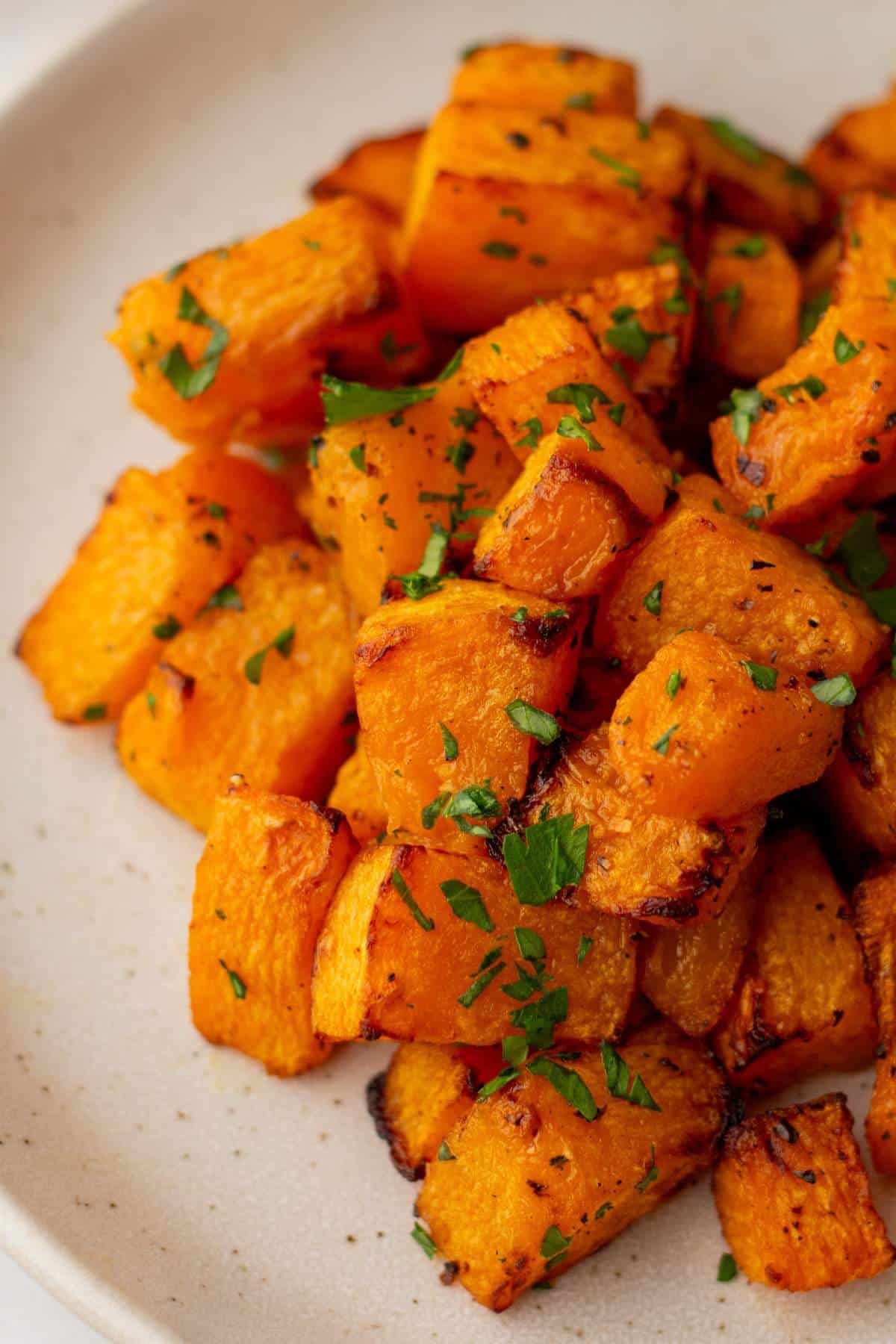 Roasted butternut squash garnished with chopped parsley.