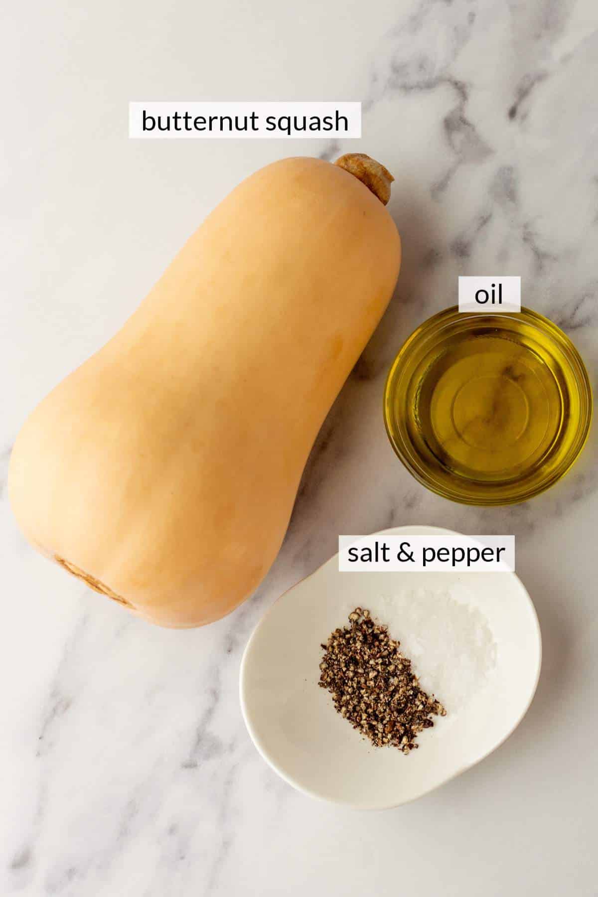 Butternut squash near a small bowl of oil and salt & pepper.