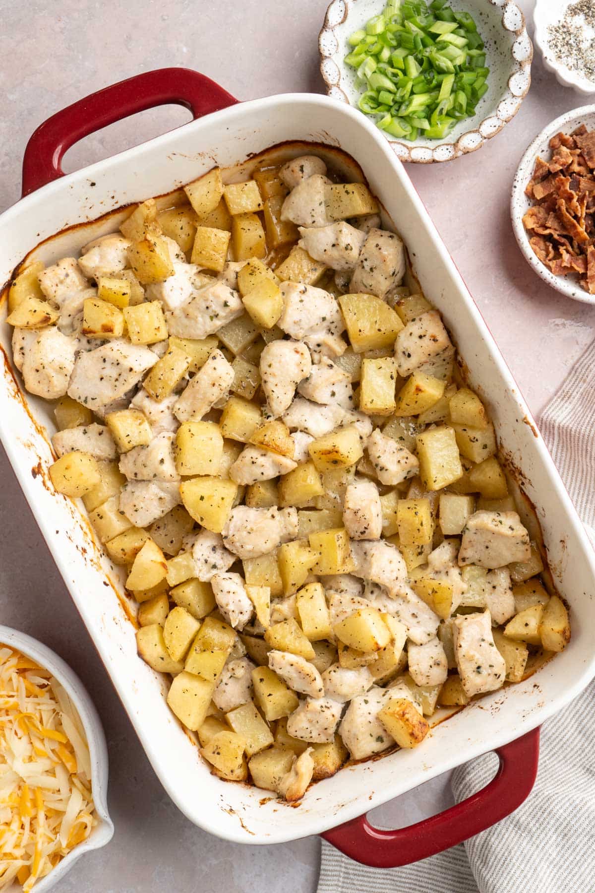 Potato and chicken pieces baked in a casserole dish.