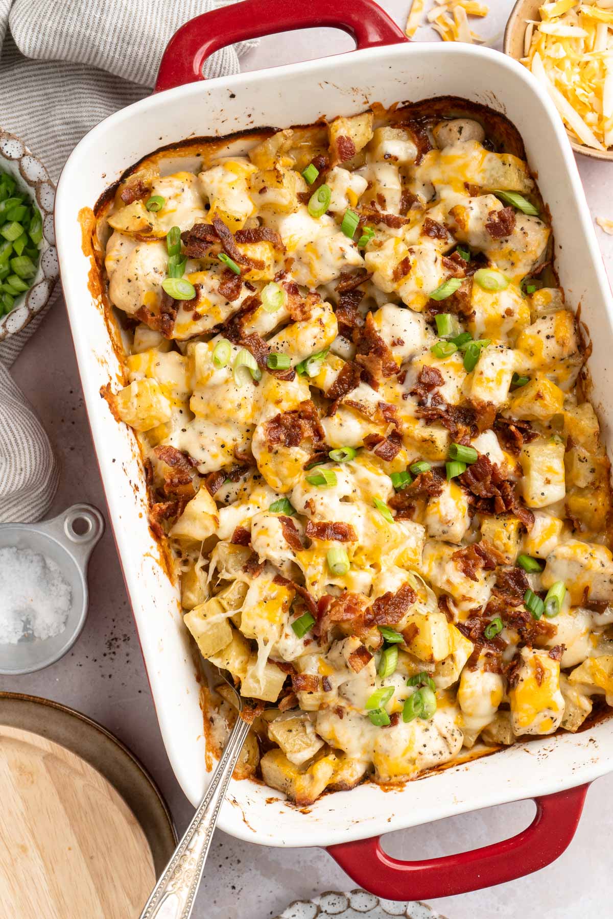 Chicken bacon ranch casserole in a casserole dish with a serving spoon.