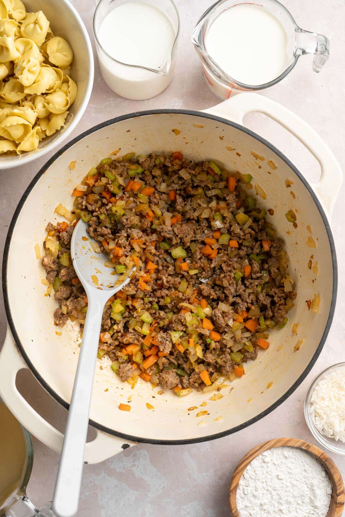 Browning sausage with carrots, celery and onion in a large pot.