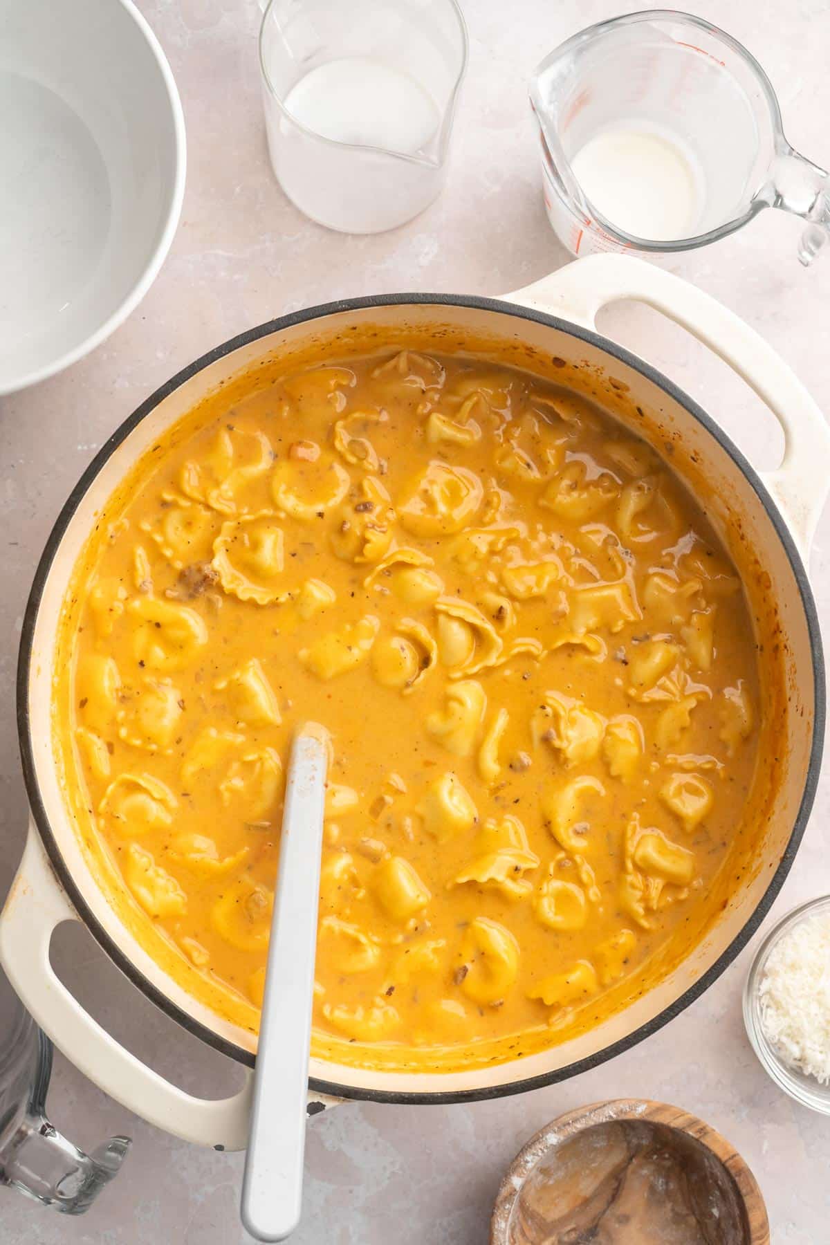 Creamy tortellini soup cooking in a large stockpot.