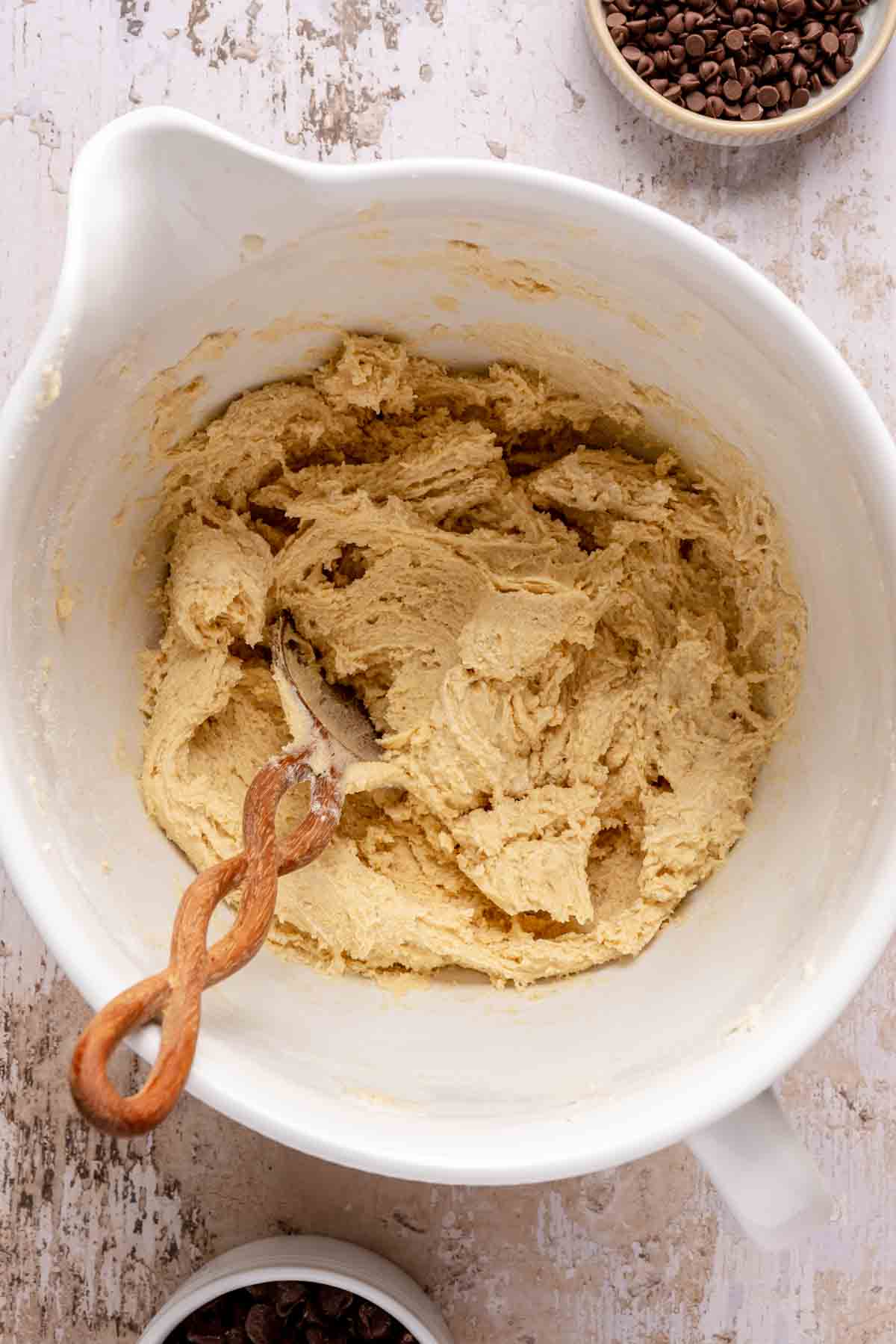 Stirring flour and pudding mix with wet ingredients in a large bowl.