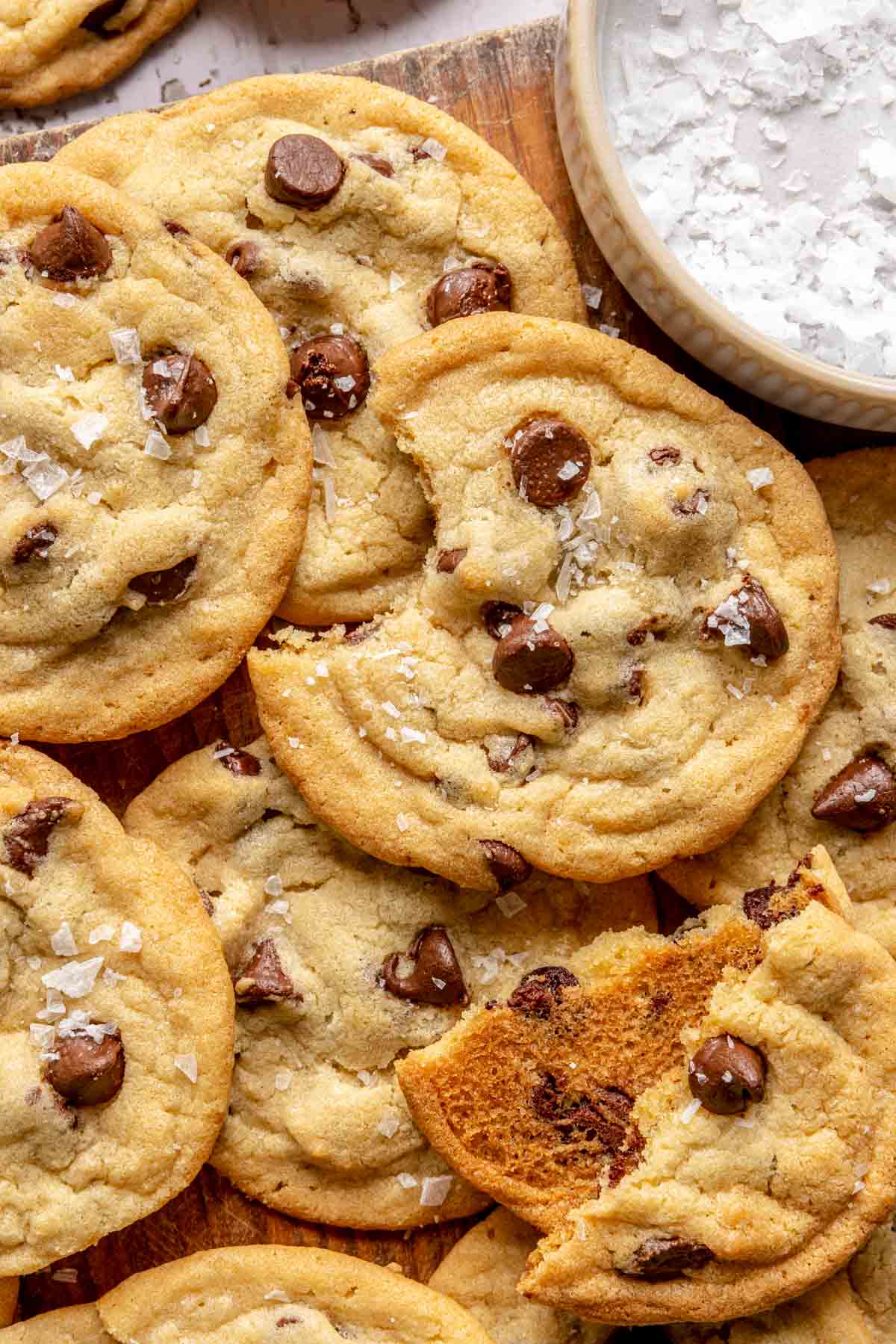 Chocolate chip cookies with flaky sea salt layered on top of one another.