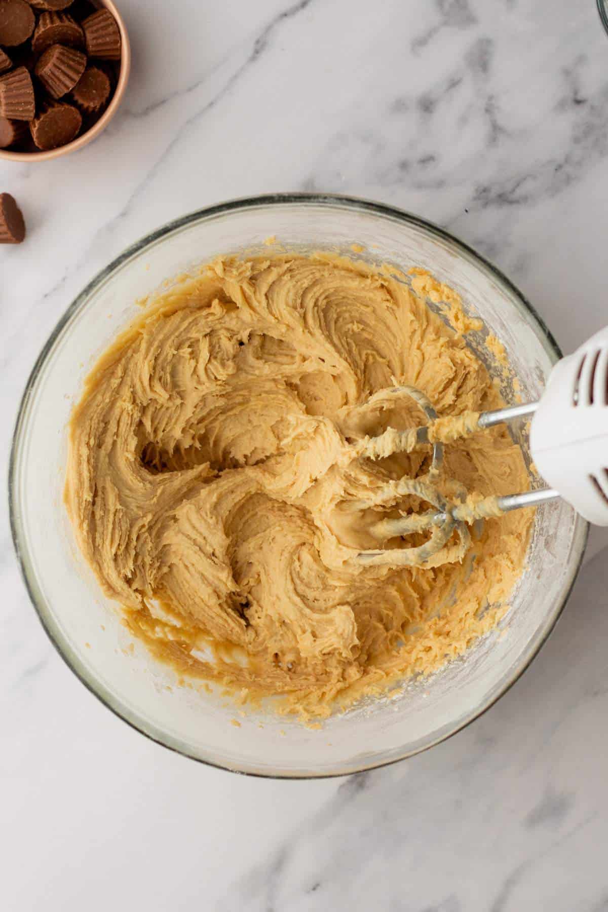 Beating together peanut butter frosting.